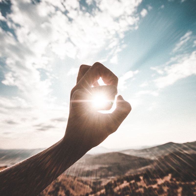 Hand curled focusing in on sun 